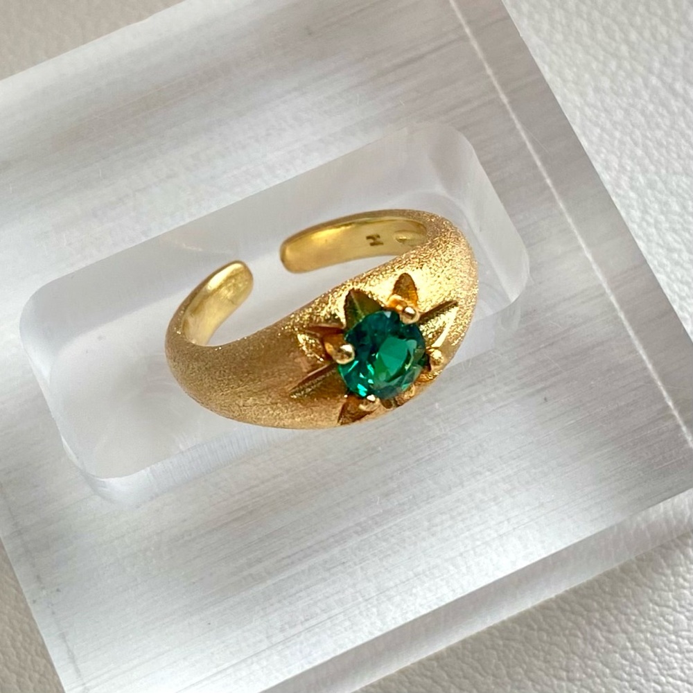 Gold and emerald ring with a starburst design